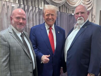 President Trump giving a thumbs up standing with leaders of the ILA